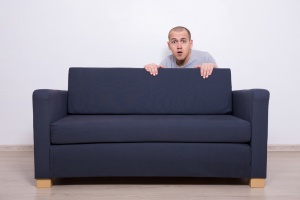 Man hiding behind couch.jpg
